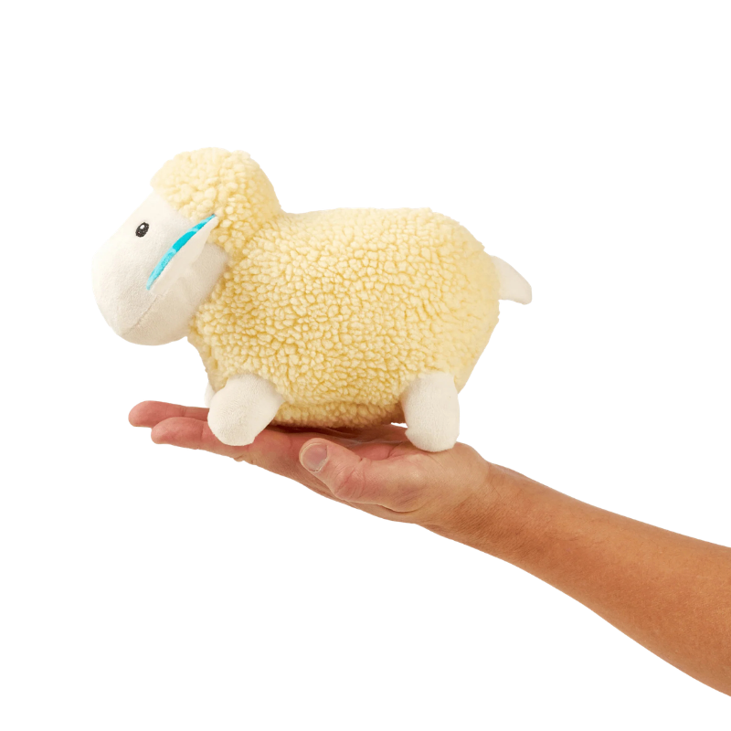 Peluche pour chien Barbara le mouton dans une main pour montrer la taille