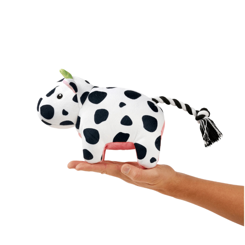 Peluche pour chien Claire la Vache posée sur une main pour montrer la taille