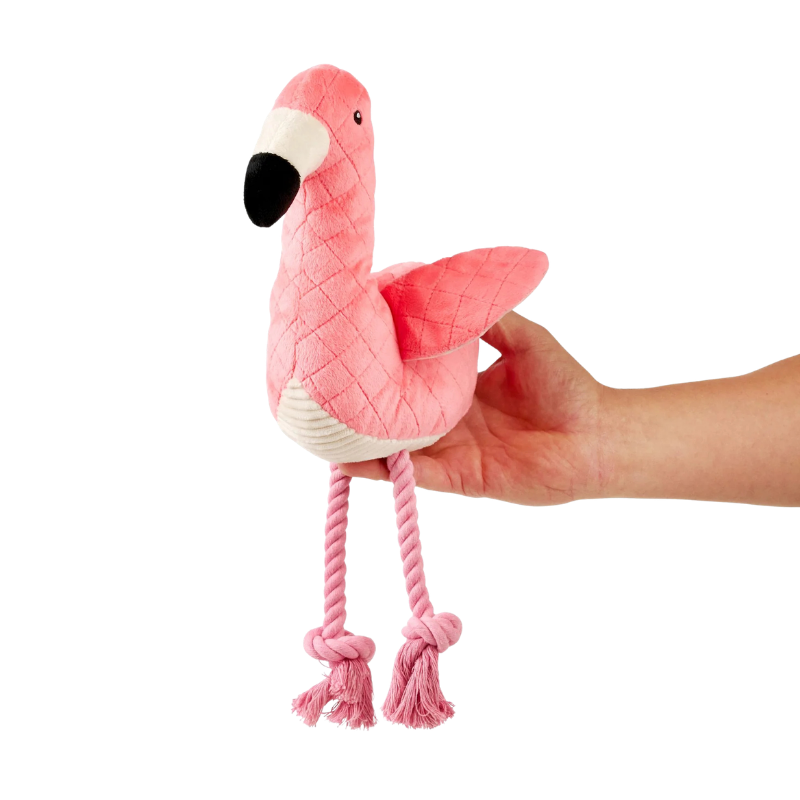 Peluche pour chien Sunny le Flamand rose dans une main pour montrer la taille