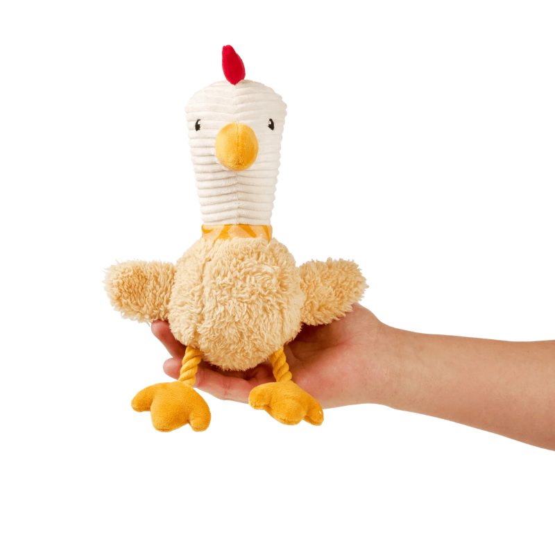 Peluche pour chien Egssy le poulet posé dans une main pour montrer la taille